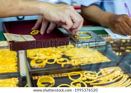 Selective focus to weighing gold jewelry with small digital scales in gold jewelry shop. Yaowarat gold shop, Thailand.