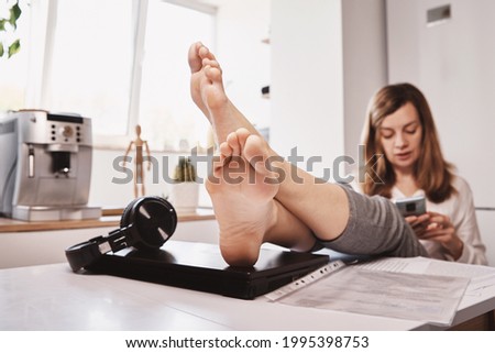 Woman procrastinate ar remote work. Freelancer use smartphone at home office. Unproductive office worker Royalty-Free Stock Photo #1995398753