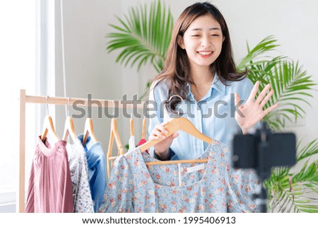 Portrait of a young businesswoman who is broadcasting live selling clothes Royalty-Free Stock Photo #1995406913
