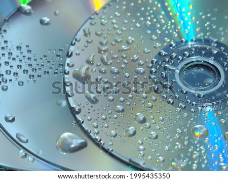 Blue reflective CD texture, small droplets of water, technology background picture.