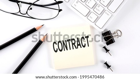 Text CONTRACT on sticker with keyboard , pencils and office tools