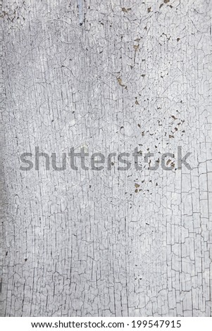 vertical picture of board with peeling white and grey paint