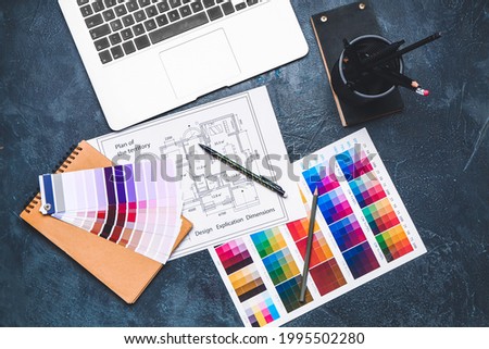 Color palettes with building plan and laptop on dark background