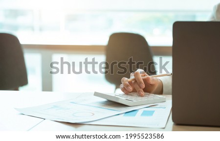 Close up accounting or businesswoman calculating income-expenditure and analyzing real estate investment data, Dedicated to the progress and growth of the company, Financial and tax systems concept
