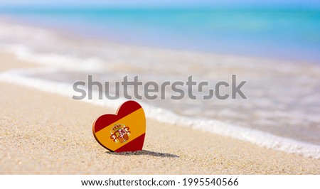 Flag of Spain in the shape of a heart on a sandy beach. The concept of the best vacation in Spain Royalty-Free Stock Photo #1995540566