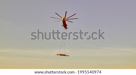 The world's largest cargo helicopter hovers overhead. Bottom view.The world's largest cargo helicopter transports cargo on a wire rope. Bottom view