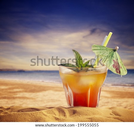 Cocktail on sandy beach at sunset. summer holiday concept. Royalty-Free Stock Photo #199555055