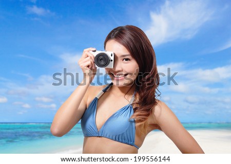 Bikini woman with camera having fun playful laughing with sea beach background, asian girl