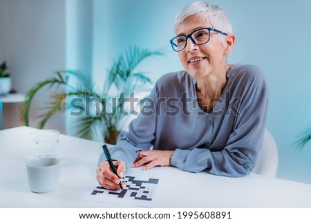 Crosswords. Cognitive rehabilitation therapy for senior women. Royalty-Free Stock Photo #1995608891
