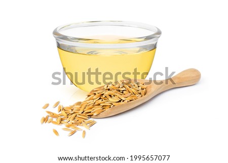 Rice bran oil extract with paddy unmilled rice on white background.  Royalty-Free Stock Photo #1995657077