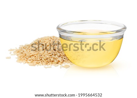 Rice bran oil extract with pile of brown rice isolated on white background.  Royalty-Free Stock Photo #1995664532