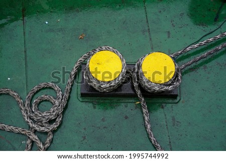  Ropes rolled up in the bow of the ship to bind the ship when it docked in port. The dark green floor of the ship is the background for this photo                          Royalty-Free Stock Photo #1995744992