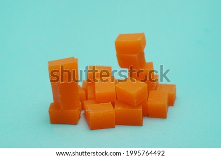 Pile of orange candy cubes on a blue background