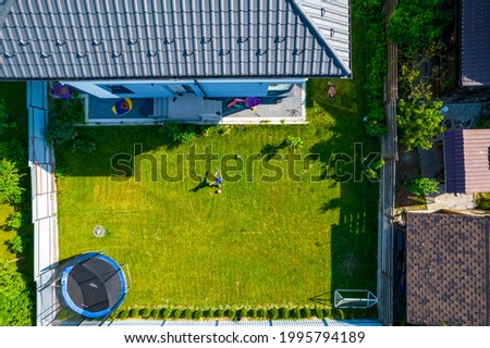 Aerial view of the courtyard of the house, a boy playing football