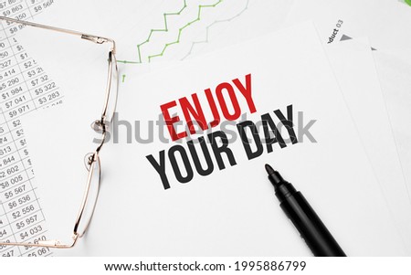 Enjoy Your Day . Conceptual background with chart ,papers, pen and glasses
