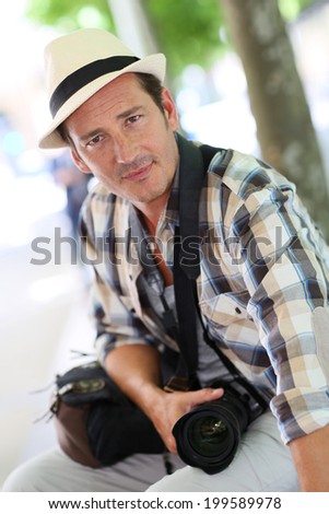 Portrait of smiling photo reporter walking in town