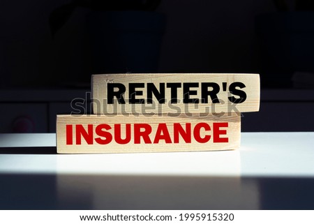 the word RENTER'S INSURANCE is written on a wooden cubes structure. Cube on a bright background. Can be used for business, marketing, financial, INSURANCE concept. Selective focus.