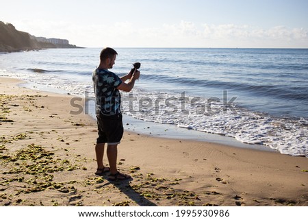 man blogger with video and photo cameras making photos of sea in Bulgaria, Nessebar