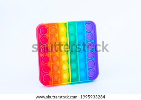 Colorful rainbow poppit game. Silicone fidget close-up on a white background Royalty-Free Stock Photo #1995933284