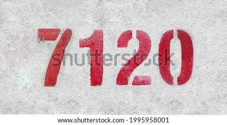 Red Number 7120 on the white wall. Spray paint. Number seven thousand one hundred and twenty.