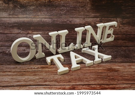 Online Tax word alphabet letters on wooden background