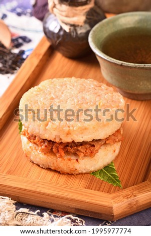 Rice burger with kimchi pork on wooden tray   