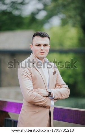A vertical shot of a young handsome Caucasian male wearing a nice elegant suit