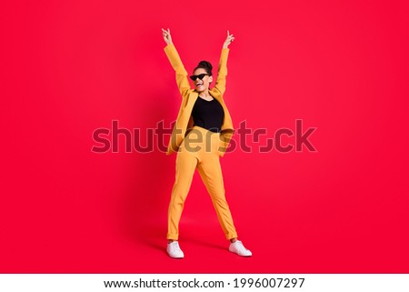 Full body photo of funny lady stand wear eyewear yellow suit isolated on vivid red color background