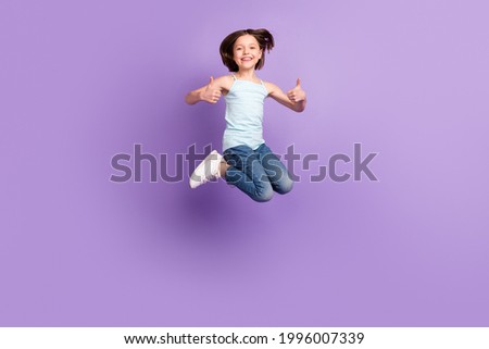 Full length photo of brown bob haired small girl jump up make thumbs up isolated on purple color background