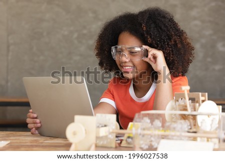 Acgirl curly hair style wearing safety glasses using tablet searching  for information from the Internet to develop the simulation mechanism robot model.cyber love