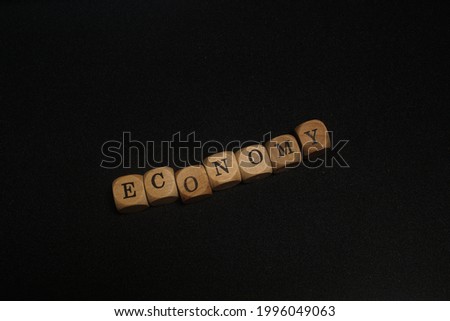 word ECONOMY written in cube wood with black background