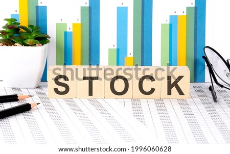STOCK word written on wood block with chart, glasses and pencils