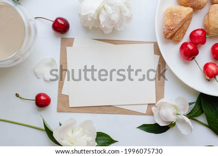 invitation card mockup and coffee, homemade cookies and cherry with peony flowers