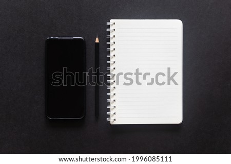 Black desk office with laptop, smartphone and other work supplies with cup of coffee. Top view with copy space for input the text. Designer workspace on desk table essential elements on flat lay.