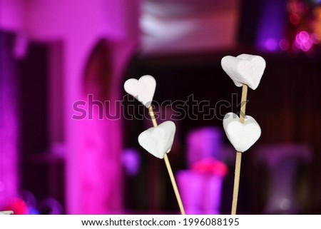 The concept of the holiday.white marshmallows in the shape of hearts on a fuchsia background congratulate you on Valentine's Day.