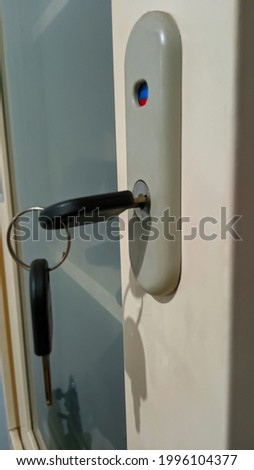 Key hanging on the glass cupboard door.
