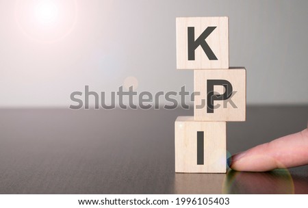 Businesswoman made word kpi with wood building blocks.