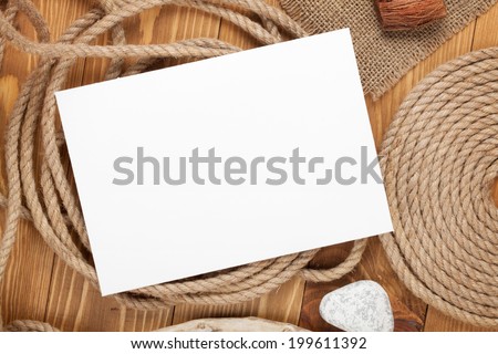 Blank photo frame with ship rope over wooden background