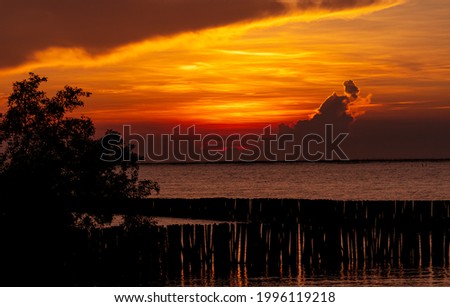 Beautiful red and orange sunset sky over the tropical sea. Red sunset sky. Skyline at the sea. Tropical sea. Scenic view of sunset sky. Calm ocean. Seascape. Art picture of clouds layer on sunset sky.