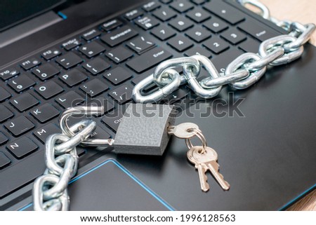 open hinged iron lock with keys and an iron chain on the laptop keyboard concept information protection internet censorship. High quality photo