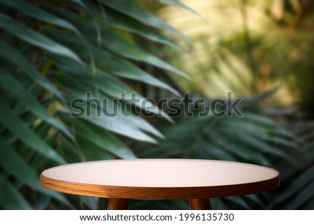 Jungle table background. Interior table for a cosmetic item against the backdrop of tropical plants, palms and jungle. Royalty-Free Stock Photo #1996135730