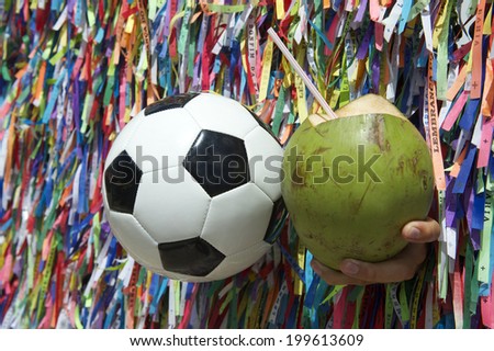 Brazilian culture with football soccer ball and fresh green coco gelado coconut at wall of wish ribbons in Salvador Bahia Brazil