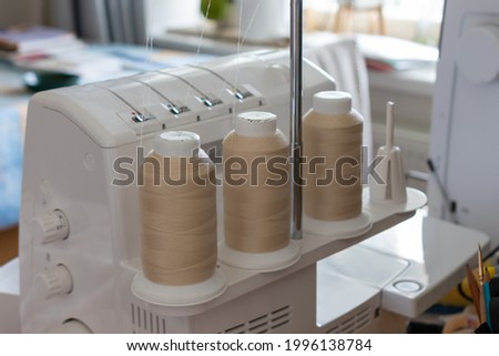 three spools of thread on the back of the sewing machine