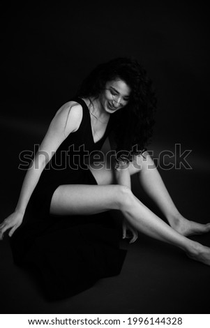 studio black and white full-length portrait of a dancer, free movements on camera, soft focus mode