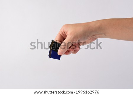 Hand and SD card isolate on white background