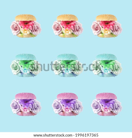Creative concept light healthy meal pattern. 
A burger stuffed with fresh flowers. Delicious, diet food on pastel blue and purple background.