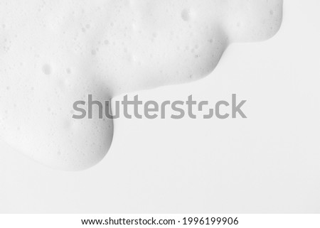 Soap foam with bubbles on white background frame with copy space, horizontal. Minimalist hygiene healthcare and medicine background. Shampoo or cleanser texture Royalty-Free Stock Photo #1996199906