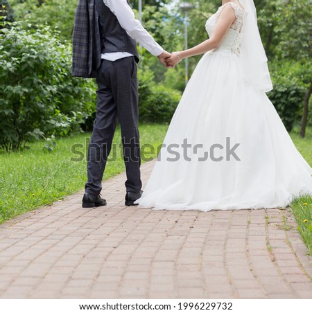 The bride and groom are walking on the path in the park