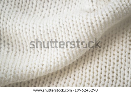 Background Of White Knitted Warm Soft Fabric Of Wool With Patterns Close Up.