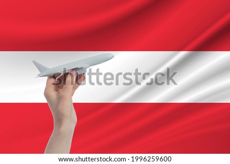 Airplane in hand with national flag of Austria. Travel to Austria.